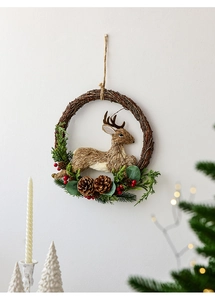 Close-up of a Christmas wreath with reindeer, pine cones, and red berries on a rustic base