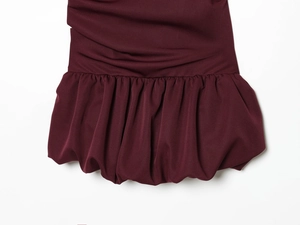 Detailed macro view of the ruffled bubble hem on a burgundy knit fashion dress
