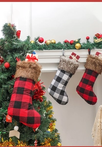 Close-up of red and white plaid Christmas stockings with faux fur trim and gift boxes