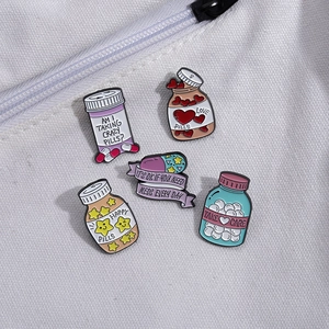 Five medical enamel pins with creative medicine bottles on a white canvas bag