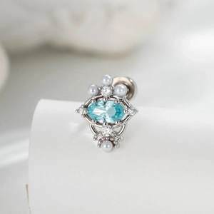 Elegant silver oval blue zircon and pearl cartilage stud earring on white display