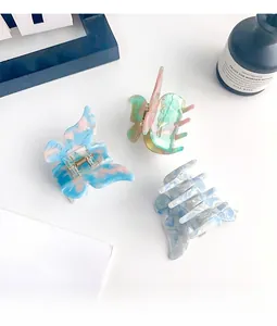 Detailed close-up of butterfly hair claws with iridescent marble pattern and acetate texture