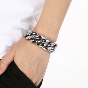 Nahaufnahme eines silbernen Panzerarmbands am Handgelenk aus poliertem Edelstahl