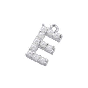Macro detail of letter F pendant with silver plating and micro-set white pearls