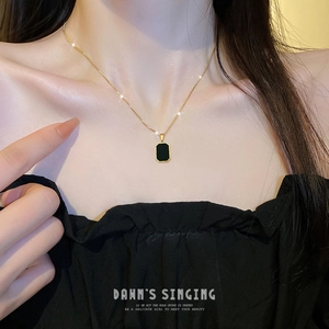 Minimalist geometric square pendant necklace in gold and black on a female model
