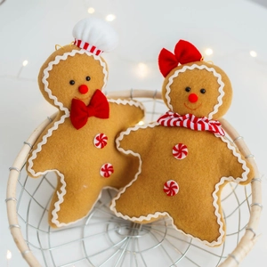 Gingerbread man plush Christmas ornaments set in a rustic wire basket with festive lights