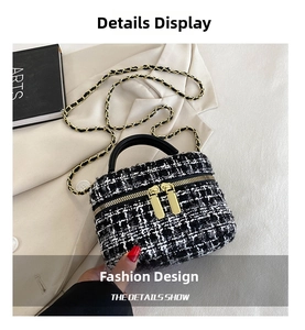 Detail van een stijlvolle zwart-witte tweed crossbodytas met een gouden kettingband