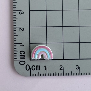 Macro shot of a mini rainbow resin accessory measuring 1.5cm on a metric scale ruler