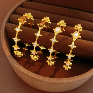 Detail of vintage gold-plated earrings with tiger eye and pearls in a velvet box