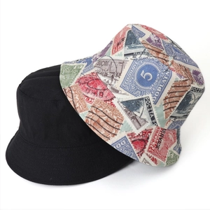 Detail view of double-sided bucket hat with vintage stamp prints and plain black side