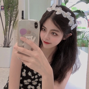 Close-up of white lace butterfly headband with pearls on a model in a mirror selfie