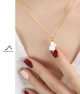 Détail d'un collier pendentif lapin en acier inoxydable doré porté par un modèle