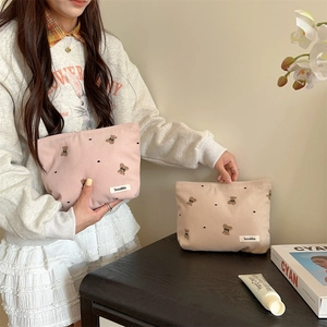 Close-up of cute bear embroidery and soft corduroy texture on the cosmetic bag