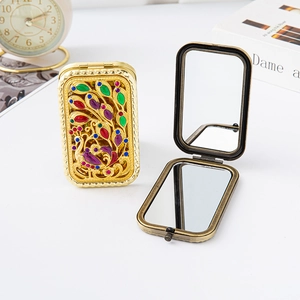 Portable vintage metal makeup mirror with colorful enamel peacock design and folding glass