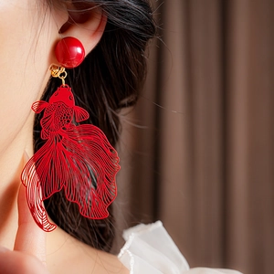 Gros plan d'un clip d'oreille poisson rouge ajouré rouge avec perle sur un mannequin