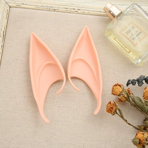 Detailed close-up of soft silicone elf ears for cosplay on a decorative fabric background