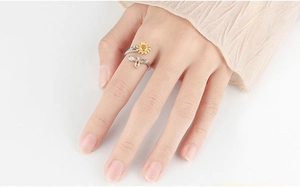 Detailed view of rotating sunflower and dragonfly stress relief ring on finger