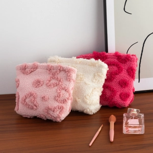 Plush heart-textured lamb wool makeup and earphone bags in pink, cream, and magenta