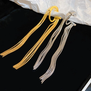 Detailed close-up of gold and silver metallic tassel ear cuffs on a contrasting backdrop