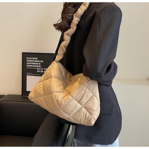 Quilted khaki puffer tote bag shown on model featuring a spacious and lightweight design