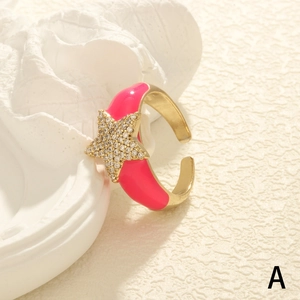 Elegant gold open star ring with pink enamel and sparkling zircon on a stone pedestal