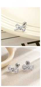 Macro detail of silver bow stud earrings with sparkling crystals and screw back closures
