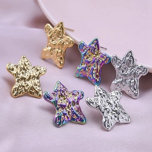 Detailed view of hammered metal star earrings in gold, silver, and iridescent finishes