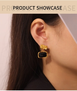 Macro detail of vintage gold-plated square earring with black glass stone on a model