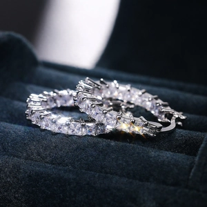 Macro shot of silver-plated hoop earrings featuring square-cut sparkling cubic zirconia