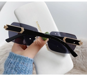 Detail of rimless gradient sunglasses with gold hollow temples and black lenses