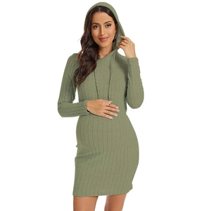 Detail of green knitted maternity dress featuring drawstring hood and ribbed texture