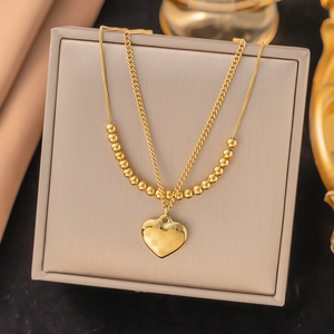 Close-up of golden double-layer necklace with heart pendant on a jewelry display box