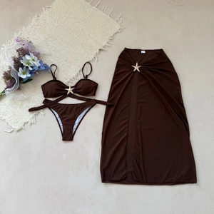 Détail d'un bikini marron avec boucles d'étoiles de mer dorées et jupe en maille assortie