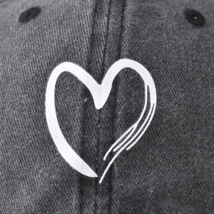 Unisex washed cotton baseball cap in charcoal gray featuring a white minimalist heart logo