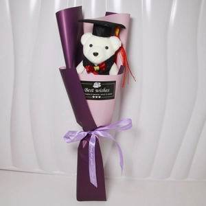 Detail of graduation teddy bear bouquet with purple wrap and sunflower soap flowers