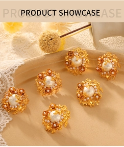 Detailed macro view of vintage gold floral earrings with baroque pearls on a lace tray