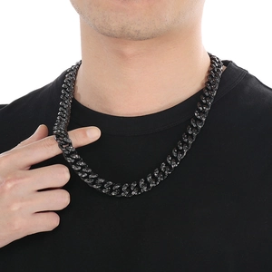 Detail of a vintage-style black stainless steel Cuban chain necklace on a male model