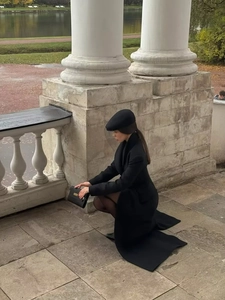 Détail d'un manteau long noir élégant en laine avec col à revers et coupe ajustée