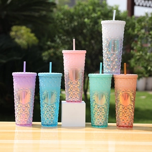 Outdoor shot of various gradient plastic tumblers with geometric diamond texture and straws