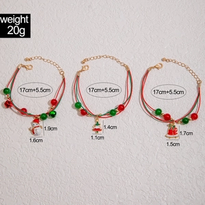 Detailed view of Christmas red cord bracelets with enamel snowman and tree charms