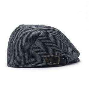 Side view of black and white herringbone tweed beret showing detailed fabric and buckle