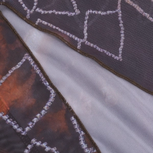 Détail macro du tissu en maille respirante avec imprimé floral et coutures de précision