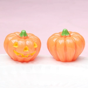 Detail of 3D luminous Halloween pumpkin figurines with Jack-O'-Lantern smile on white tray