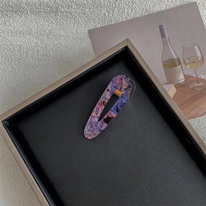 Detailed macro view of purple marble texture hair clip on elegant decorative base