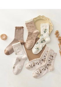 Detail shot of vintage cotton socks with floral patterns and rabbit embroidery motifs
