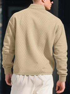 Detail shot of men's beige polo shirt showing 3D textured knit pattern and long sleeves