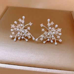 Close-up of 18k gold plated firework stud earrings with pearls and cubic zirconia