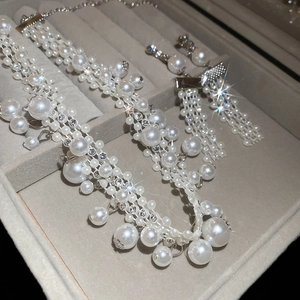 Close-up of vintage pearl and rhinestone jewelry set with tassel earrings in a velvet box