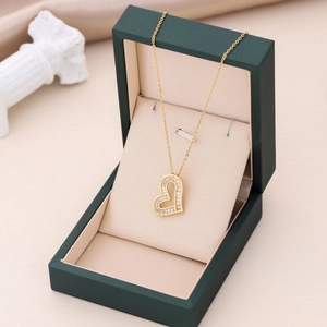 Collier à pendentif cœur doré serti de zircons dans un écrin à bijoux vert foncé