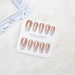 Detail of handmade nude pink ombre coffin press-on nails on luxury white fur background